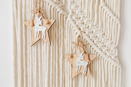 Two wooden star decorations with intricate designs are hanging from a woven wall display adding a...