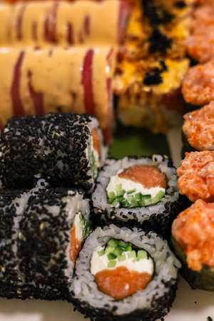 A vibrant platter features assorted sushi rolls including salmon avocado and colorful toppings perfect for sharing at a meal.の写真素材