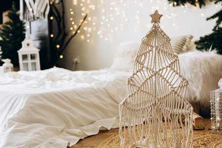 A stylish macrame Christmas tree stands in a warm room adorned with fairy lights creating a cozy and festive atmosphere.の写真素材