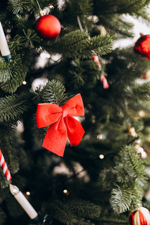 A festive Christmas tree features a vibrant red bow surrounded by ornaments creating a cheerful holiday atmosphere.の写真素材