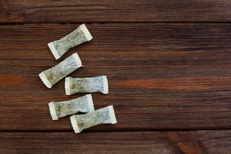 Nicotine snus pads are placed on a rustic wooden surface.の写真素材