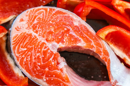 This dish features a fresh salmon fillet and red bell pepper slices showcasing vibrant ingredients...