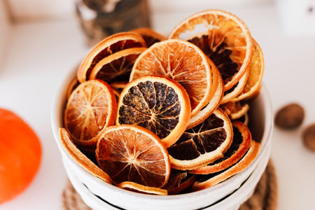 A bowl filled with dried citrus slices showcasing vibrant colors and textures sits on a table perfect for decoration or flavoring.の写真素材