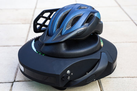 A futuristic self balancing device unicycle sits on a paved surface featuring a helmet placed on top showcasing technology and safety.の写真素材