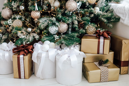 Decorated Christmas tree stands elegantly next to wrapped gifts in various colors during the festive season.の写真素材