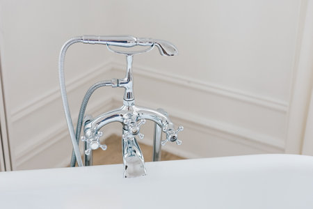 A stylish chrome faucet is installed in a contemporary bathroom enhancing the clean and bright atmosphere.の写真素材