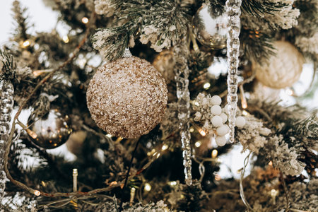 A beautifully adorned Christmas tree features sparkling ornaments and twinkling lights in a warm indoor atmosphere perfect for the holiday season.の写真素材