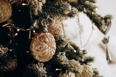 A vibrant Christmas tree adorned with gold ornaments and twinkling lights brings festive cheer to the room this holiday season.の写真素材