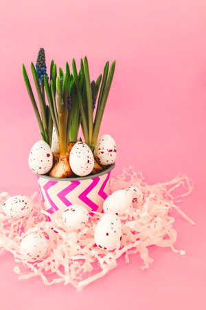 A vibrant plant with green shoots is displayed in a patterned pot surrounded by decorative eggs on a...