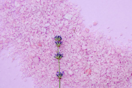 Delicate lavender flowers rest on pink salt crystals creating a tranquil and calming atmosphere perfect for relaxation and wellness.の写真素材