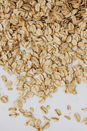 Oats are spread across a white surface showcasing their texture and color perfect for a nutritious...