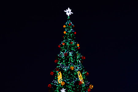 A festive Christmas tree sparkles at night with colorful lights and ornaments creating a joyful...