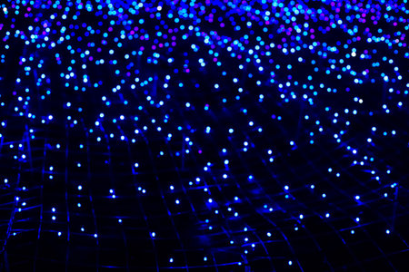 Bright blue lights twinkle and glow against a dark background forming a mesmerizing pattern. This...