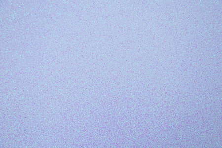A shimmering glittery surface shines under light displaying a beautiful range of pastel colors. This unique texture creates an ideal setting for crafts celebrations and artistic expression.の写真素材