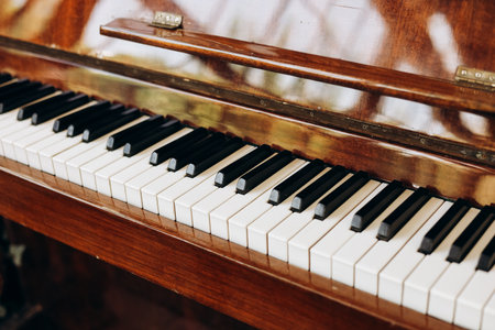 Beautiful wooden piano keys line the instrument showcasing a mix of black and white shades.の写真素材