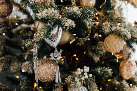 A beautifully decorated Christmas tree adorned with golden ornaments and festive accents. Warm lights glow softly creating a cozy atmosphere perfect for celebrating the holiday season.の写真素材