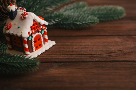 A delightful gingerbread house sits on a wooden surface featuring colorful candy decorations.の写真素材