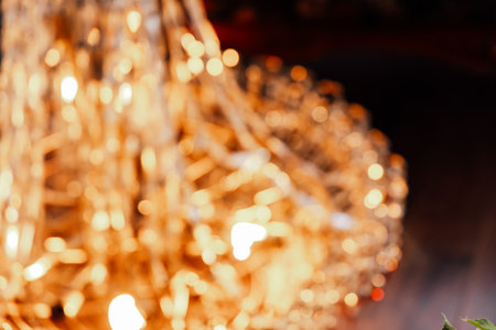 A large chandelier shines brightly above as people socialize and enjoy the evening event. The warm glow of the lights adds to the lively atmosphere of the gathering.の写真素材