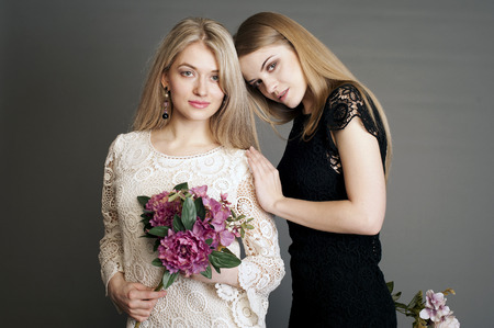 girl with flowers, bouquet, beautiful bouquet in hands at the girl, two girls, two blondes, girlfriends, young girlsの写真素材