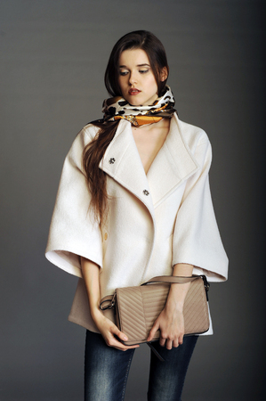coat, white coat, girl in a white coat, ladies' handbag, handbag, woman with a handbag, clutch, girl with a clutchの写真素材