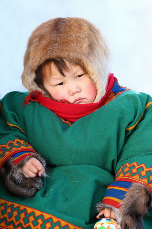 NADYM, RUSSIA - MARCH 14, 2015: the girl the Nenets woman in fur clothes sits in a sledge during a traditional holiday "Day of the reindeer breeder". Nenets - aboriginals of the Russian Northのeditorial素材