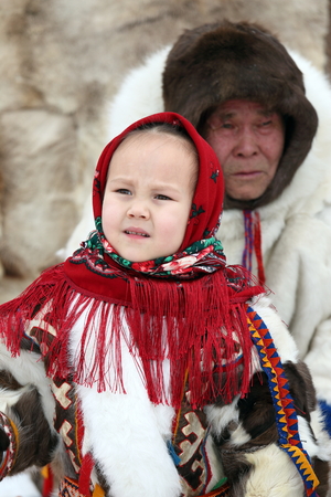 NADYM, RUSSIA - MARCH 03, 2017: Granddaughter and grandpa Nenets people in national clothes on a traditional holiday "Day of the reindeer breeder". Nenets - aboriginals of the Russian Northのeditorial素材