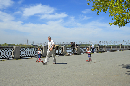 Novosibirsk, RUSSIA-JUNE 13, 2014: Grandfather walks with two twin girls along the Ob river embankmentのeditorial素材