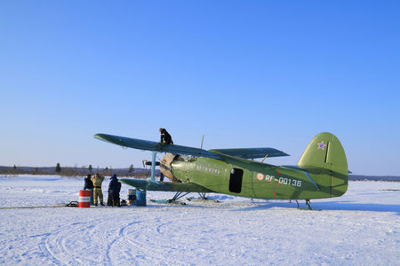 Nadym, RUSSIA-FEBRUARY 26, 2012: The crew of an an-2 biplane pours fuel from barrels into the aircraft's tanks on a winter snow fieldのeditorial素材