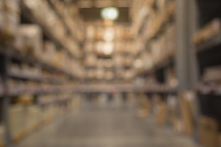 Rows of shelves with boxes in a modern warehouse background blurredの写真素材