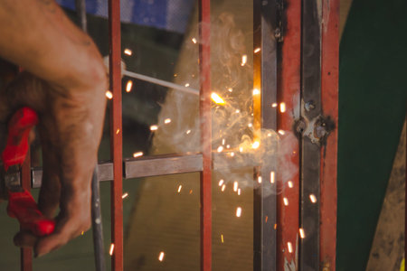 Craftsman sawing metal sparkles all around workshop