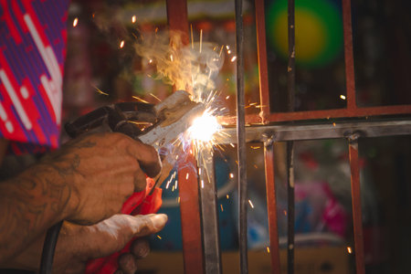 Craftsman sawing metal sparkles all around workshop