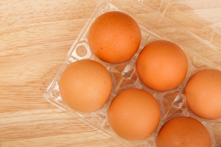 Brown eggs in a box for eggs on a wooden tableの写真素材