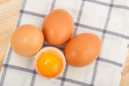Brown eggs on a beautiful cloth background on a wooden tableの写真素材