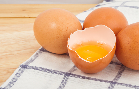 Brown eggs on a beautiful cloth background on a wooden tableの写真素材