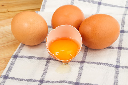 Brown eggs on a beautiful cloth background on a wooden tableの写真素材