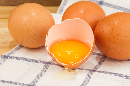 Brown eggs on a beautiful cloth background on a wooden tableの写真素材