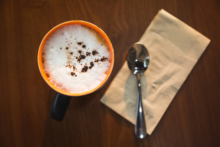 Latte coffee on warm light wooden table top viewの写真素材