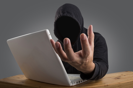 hacker hacking computer network with laptop, Dark face hackerの写真素材