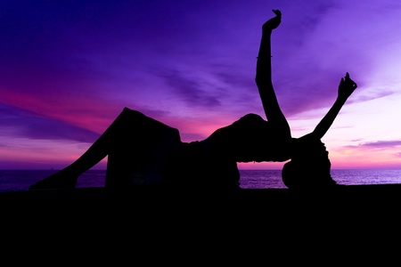 Silhouette of young sensuality beautiful woman during sunsetの写真素材