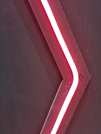 Red neon sign on a black wall, with copy space for textの写真素材