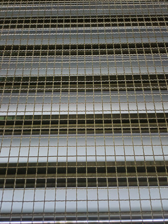 Close up of metal grating on a building wall for background.