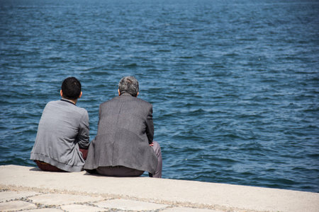 Two turkish sit along the Izmir bay  They are talk and listen  They spend their free time for enjoy the scene of the sea の写真素材
