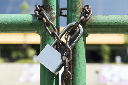 Padlock with chain on old steel doorの写真素材