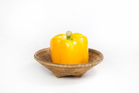Yellow bell pepper in basket on white backgroundの写真素材