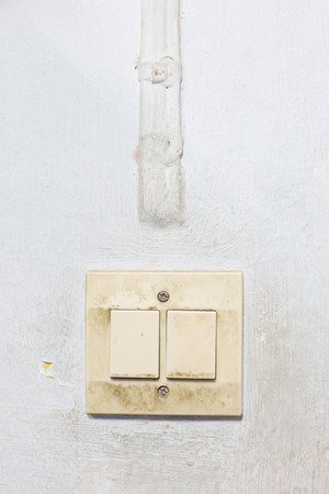 Old electric switch and electric cable at wallの写真素材