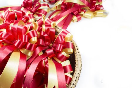 Gold and red ribbons with bow and space for text on white background.の写真素材