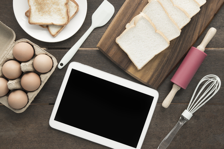 Baking utensils tool and eggs tablet clipping path at screen retro style on chopping board wooden background topview flatlayの写真素材