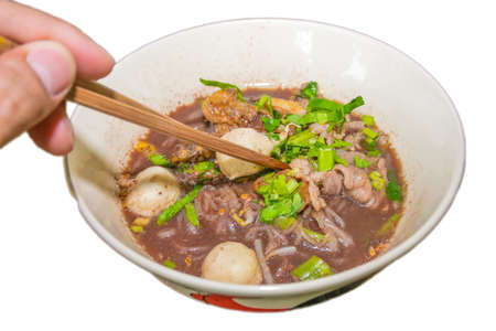 It is Pork Waterfall noodles (Kuay teow nam tok moo) Thai culture and Thai style spicy soup noodle a Thai noodle with cooked pork have vegetables isolatedの写真素材