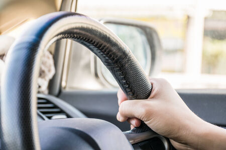 Close-up of a woman hand on a steering wheel in a modern carの写真素材