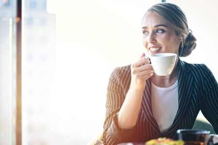 Businesswoman drinking coffee in a cafe.の写真素材
